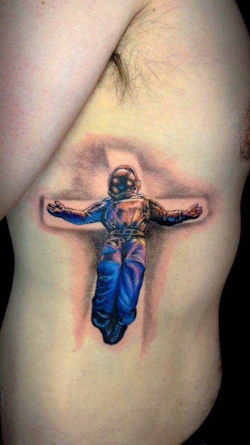 Astronaute crucifix couleur sur les côtes — sarahtattooos