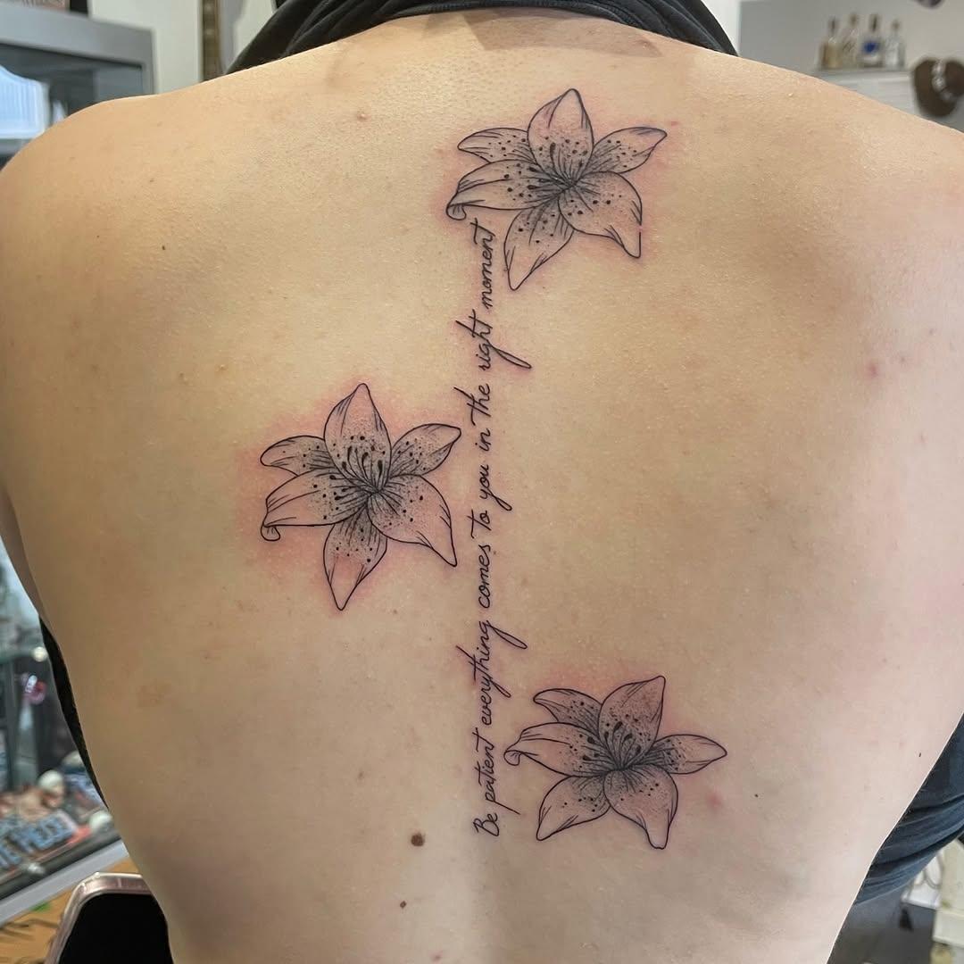 Lys et lettrage fine line dans le dos — tache_n0ire