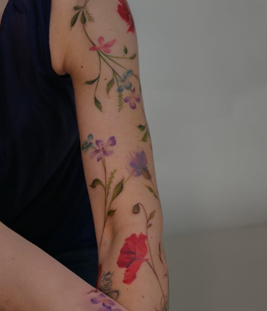 Tatouage fleurs multicolores et feuillage — katetadako.tattoo