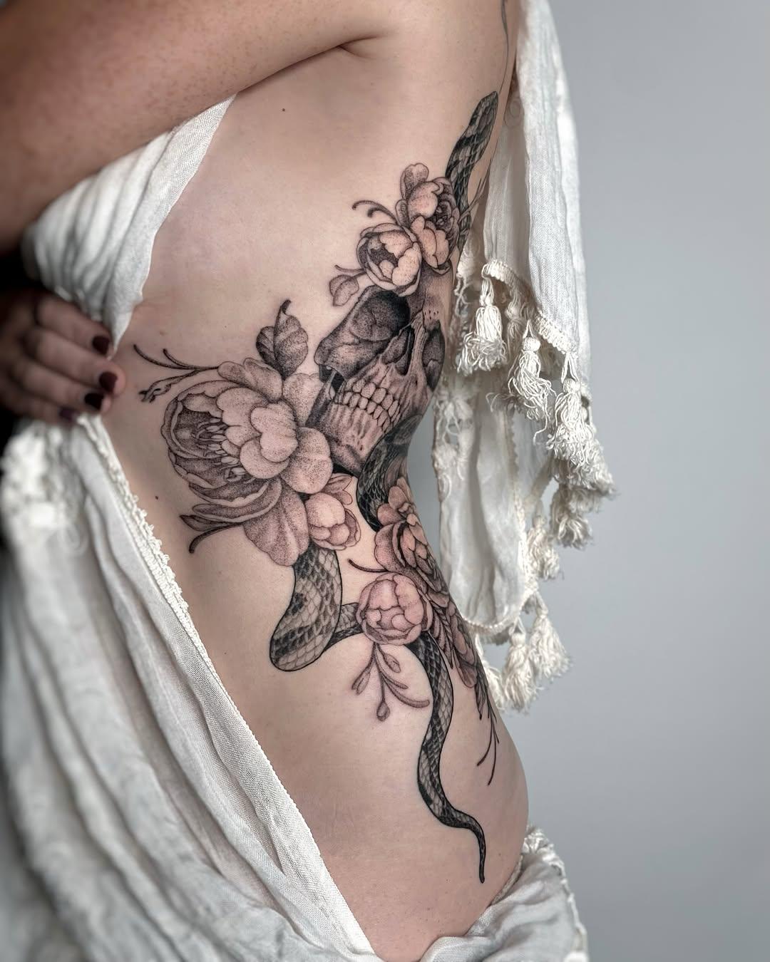 Tatouage serpent et crâne floraux côte — clarisseamourtattoo
