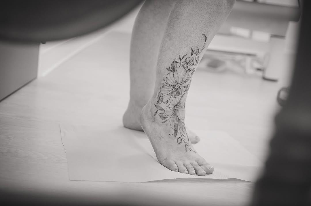 Tatouage Fleurs et feuillage sur cicatrices pied — evedlg