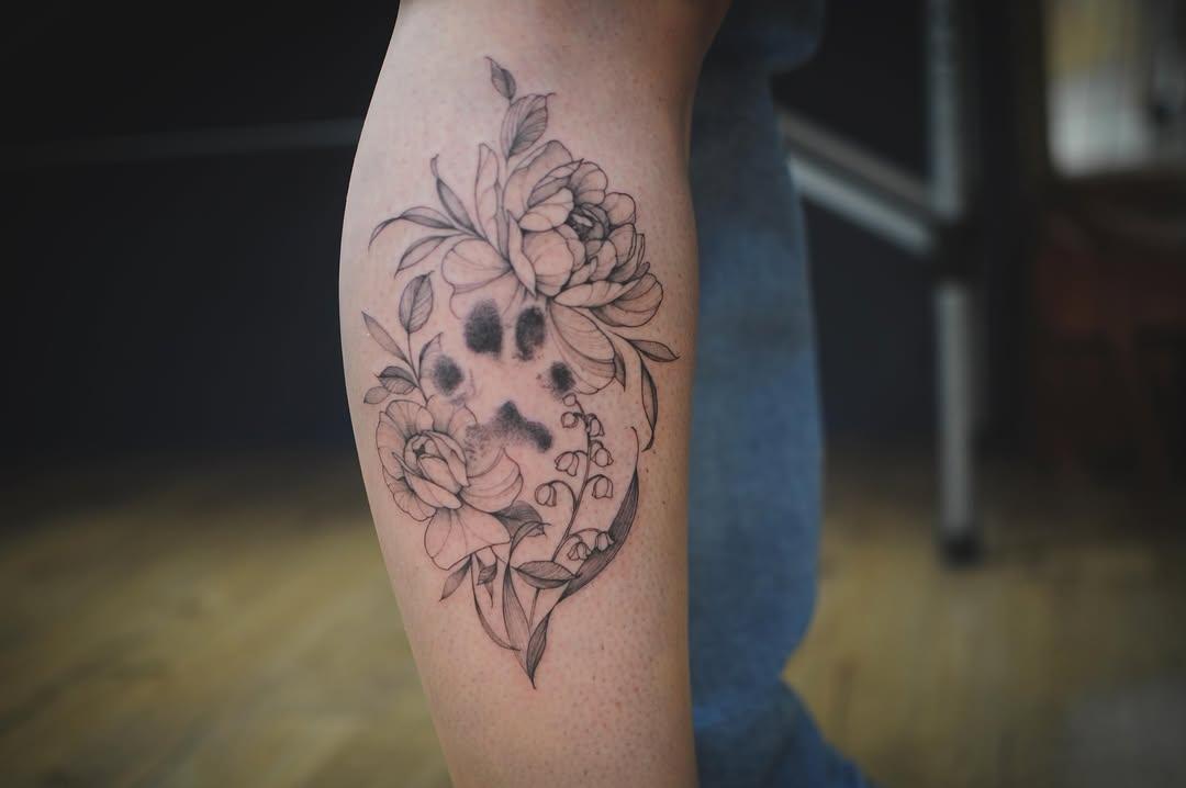 Tatouage Empreinte de patte entourée de fleurs — evedlg
