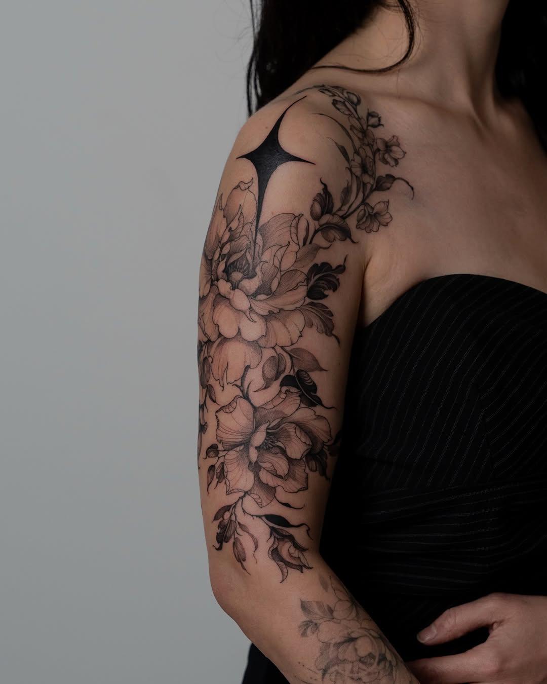 Tatouage composition florale contrastée épaule-bras — kalawa.tattooer