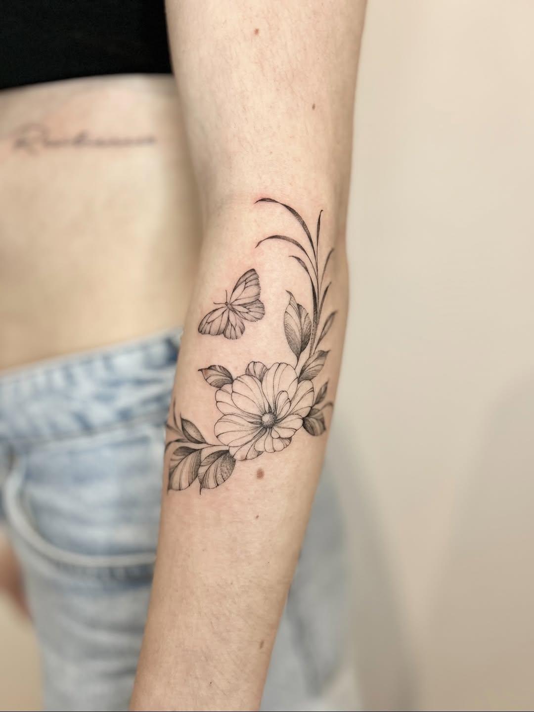 Tatouage floral et papillon fine line sur l'avant-bras — lafeefleurs
