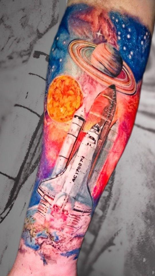 Tatouage navette spatiale et galaxie couleur sur l'avant-bras — tonieblesk