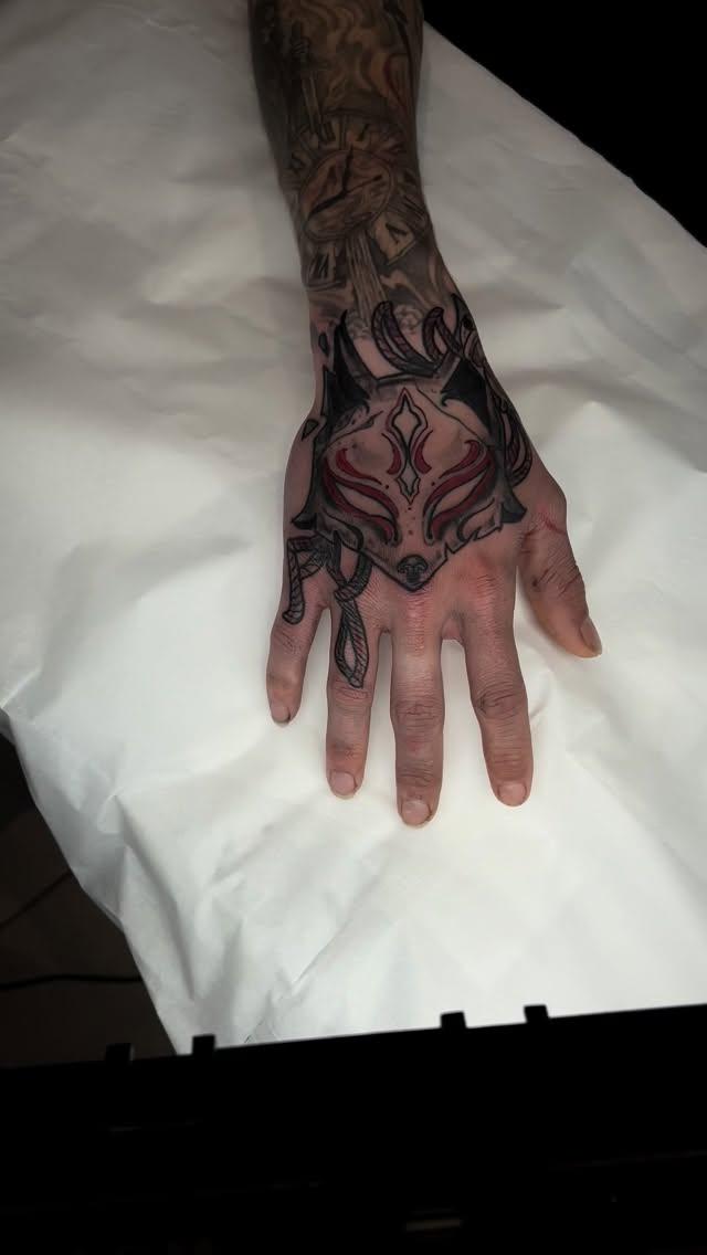 Masque de kitsune blackwork et rouge sur la main — dorianblind_tattoo
