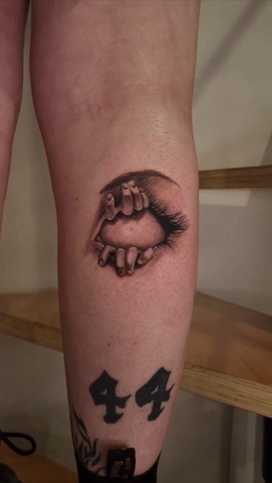 Tatouage œil réaliste avec mains sur la jambe — rmx_tattoo