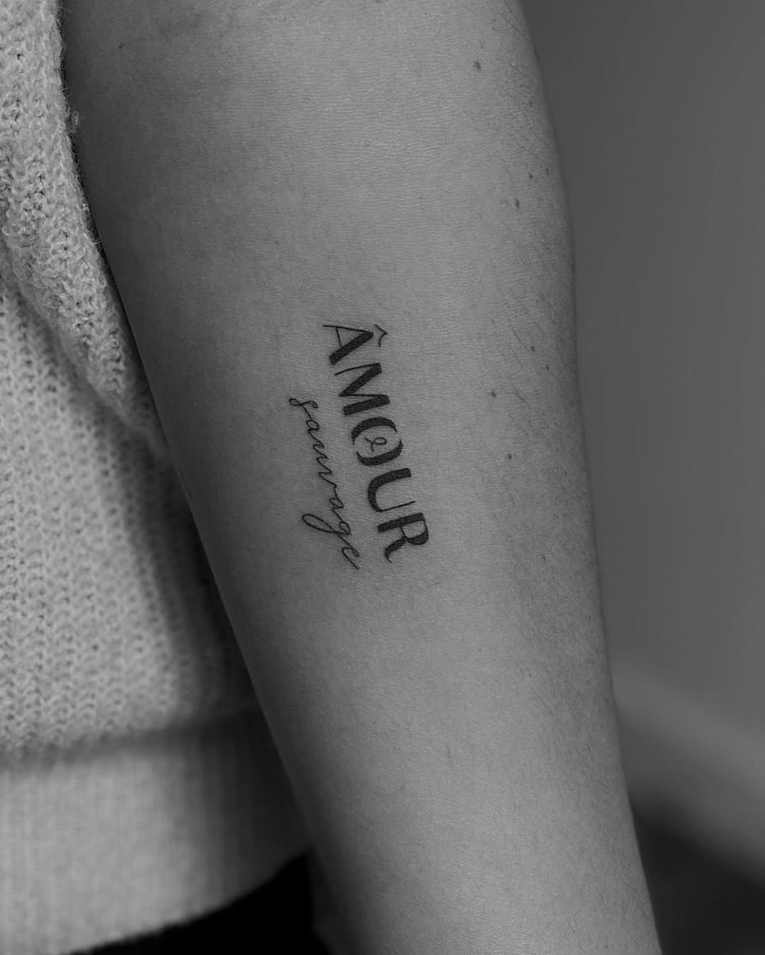 Lettrage fine line « Amour sauvage » sur l'avant-bras — maepoussin.tattoo
