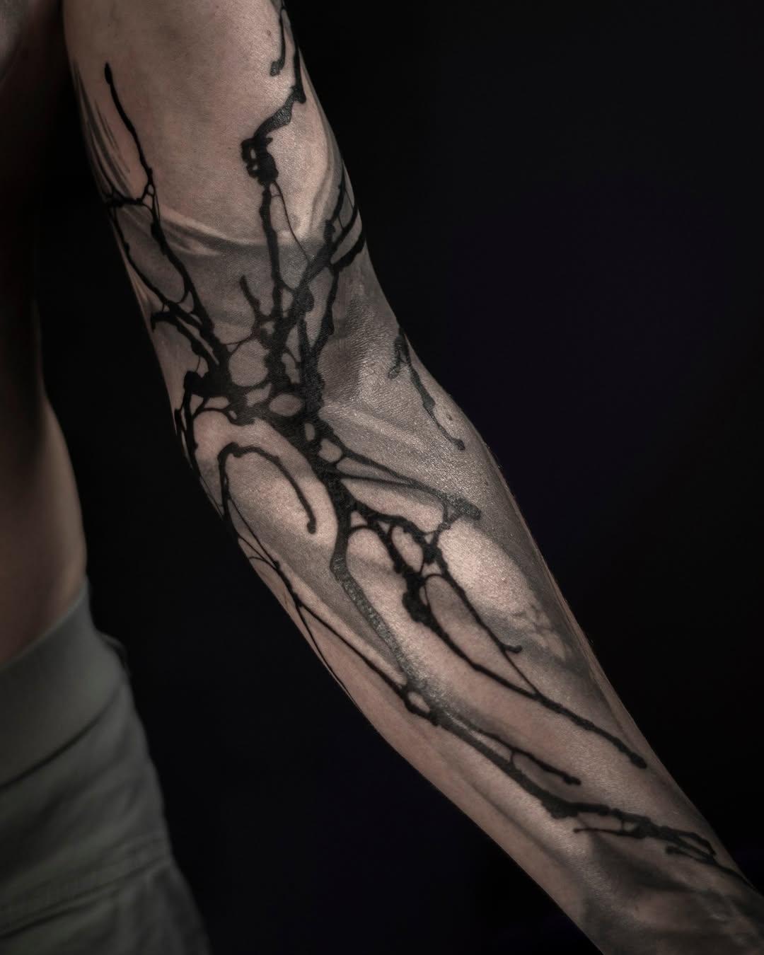 Dark brushwork tree branches tattoo covering full arm for Cédric