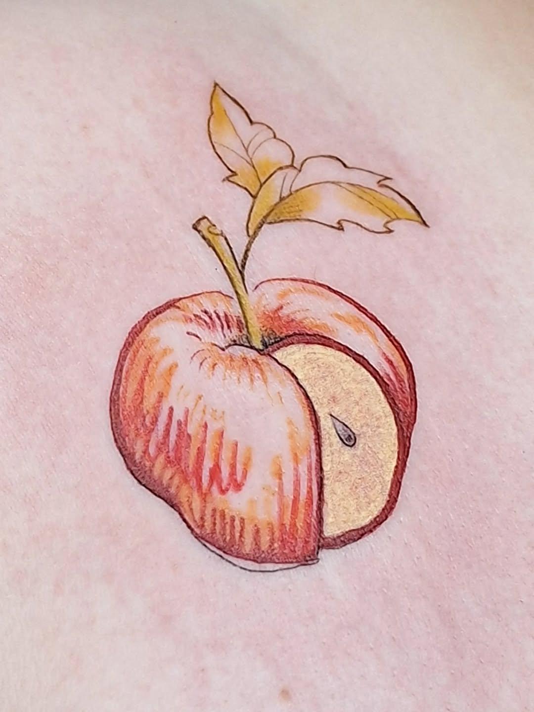 Small color apple tattoo on skin, botanical illustration style