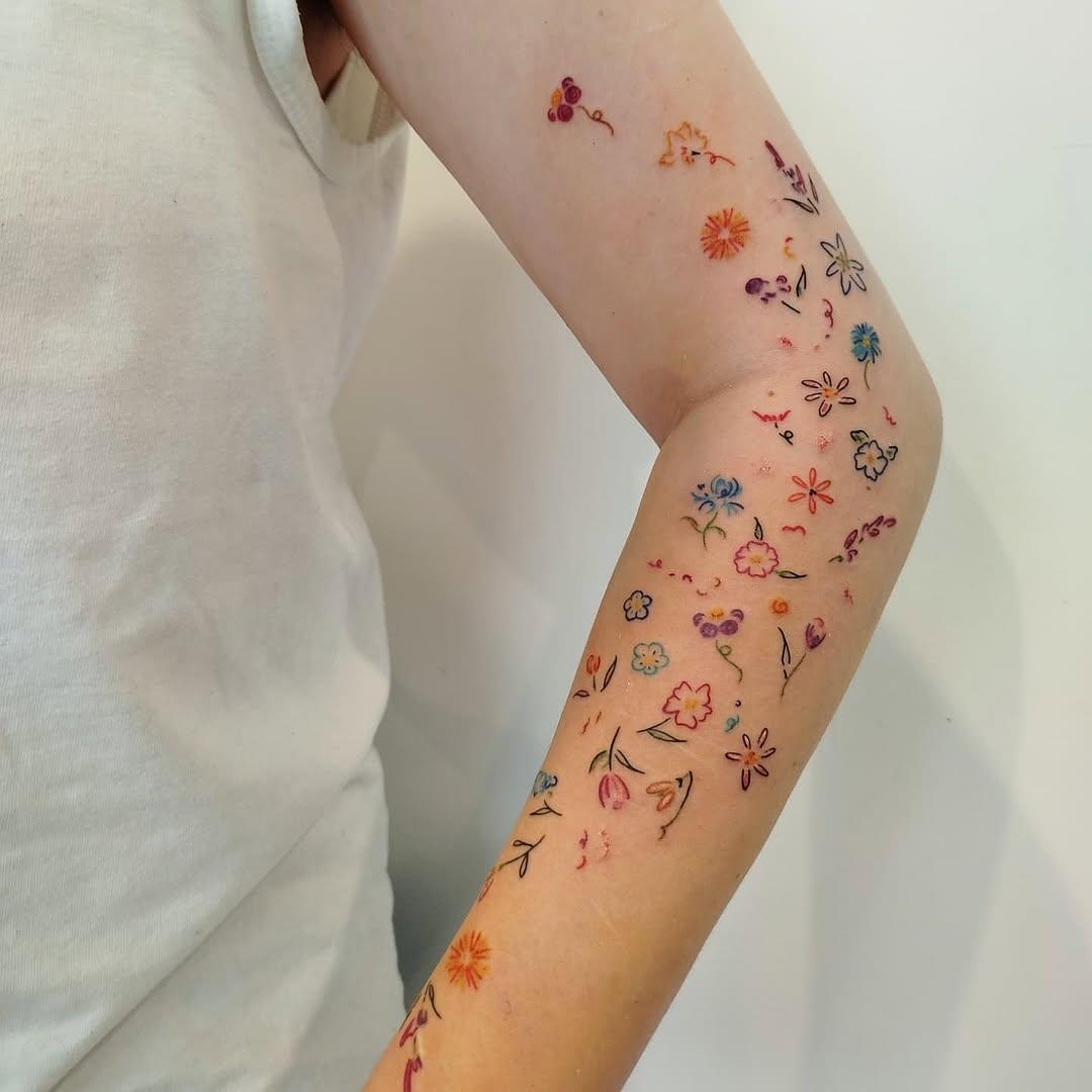 Papillons devant fleurs colorées tatouage