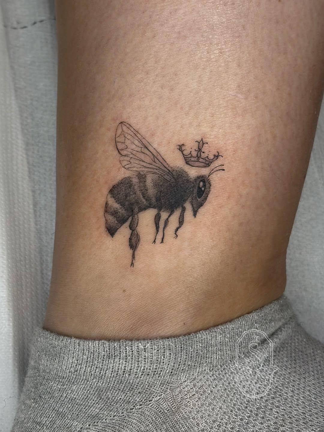 Tatouage abeille couronnée micro-réalisme black & grey — seipha